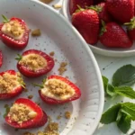 Easy Cheesecake Deviled Strawberries topped with graham cracker crumbs on a white plate