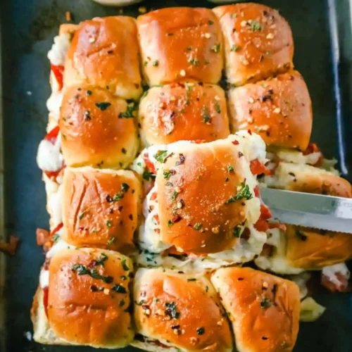 Platter of pizza sliders beside container of leftovers ready for storage.