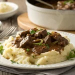 Plate of no peek beef tips with mushroom gravy over mashed potatoes