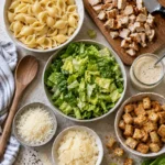 A flat-lay of ingredients for the chicken caesar pasta salad